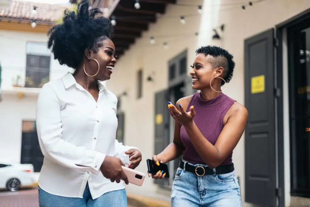 African american women talking and laughing walking in the city